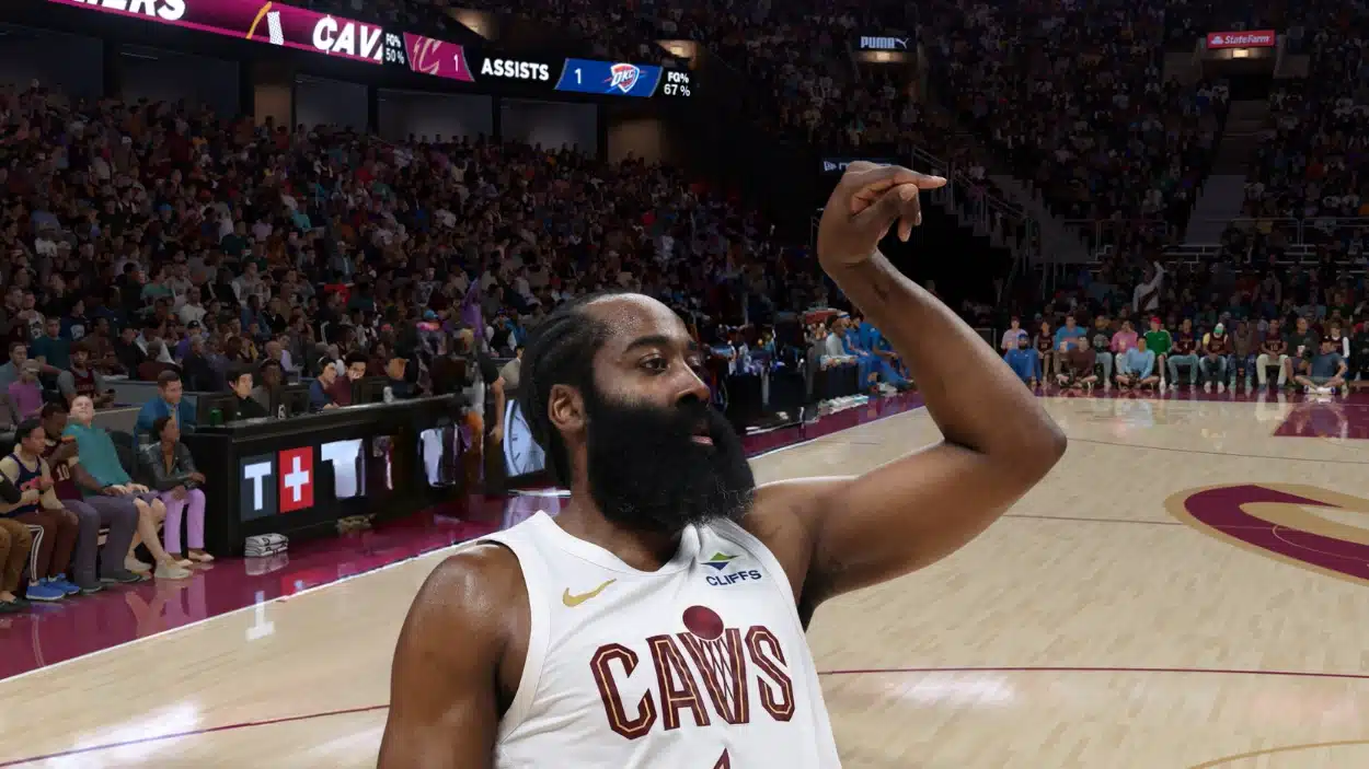 Basketball player James Harden, wearing a white Cavaliers jersey, signals to the crowd on a brightly lit court.