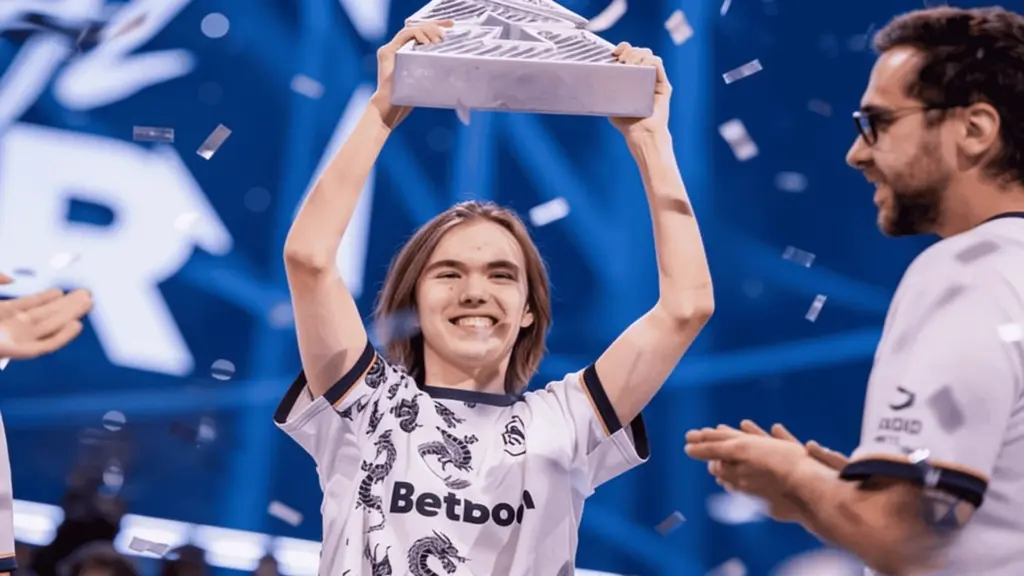 Esports player Donk from Team Spirit holding a trophy after winning a competitive gaming event