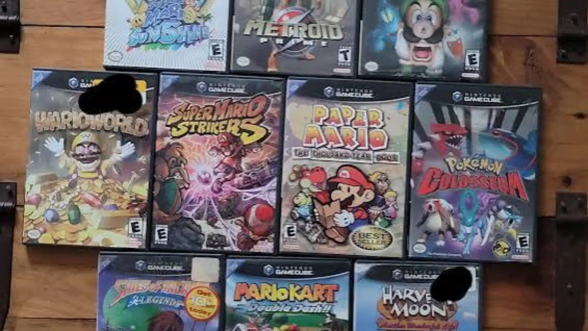 Collection of Nintendo GameCube game cases including Mario, Metroid, Luigi, Pokémon, and Mario Kart titles