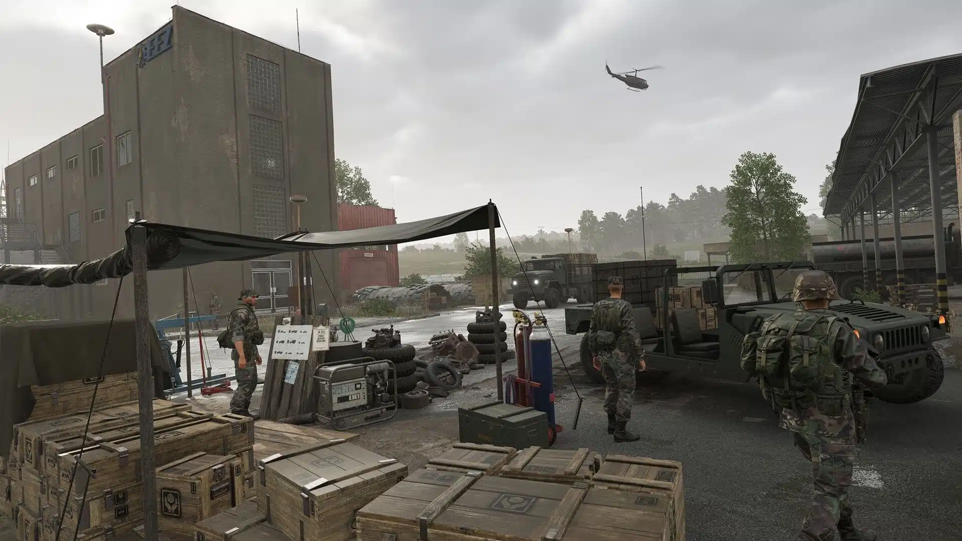 Military supply area with vehicles, equipment crates, and soldiers outdoors