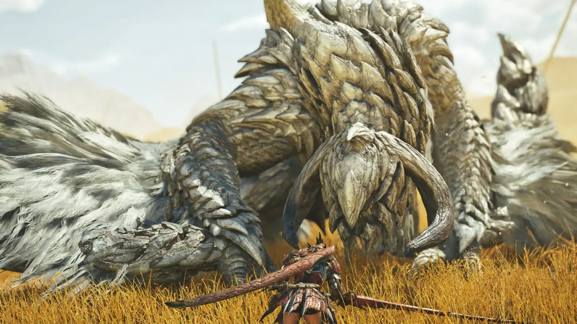 Armored hunter confronts a massive horned monster in a sunlit golden grassland field