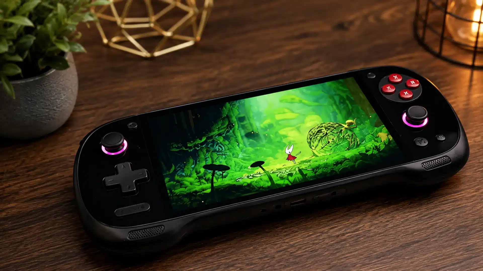 Black handheld console displays a glowing forest game on a warmly lit wooden gaming desk