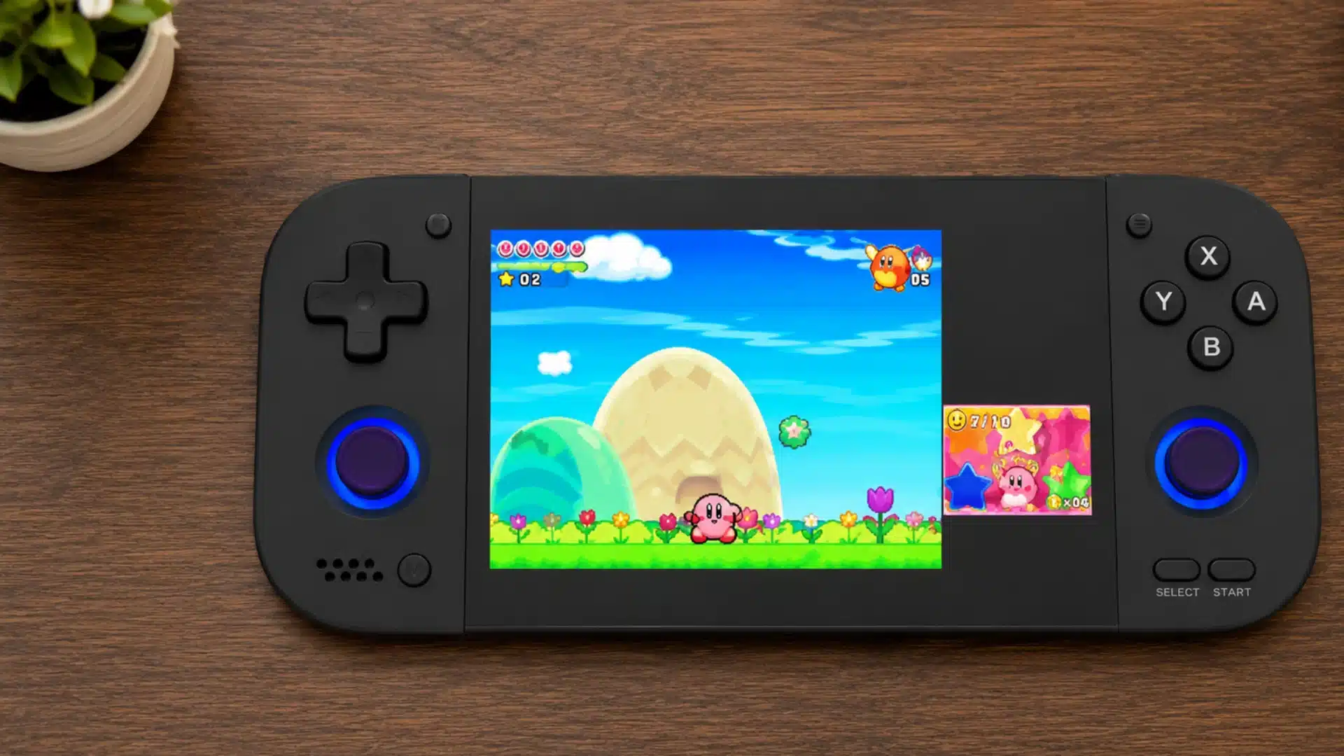 Black handheld console shows a colorful side-scrolling game on a wooden desk indoors