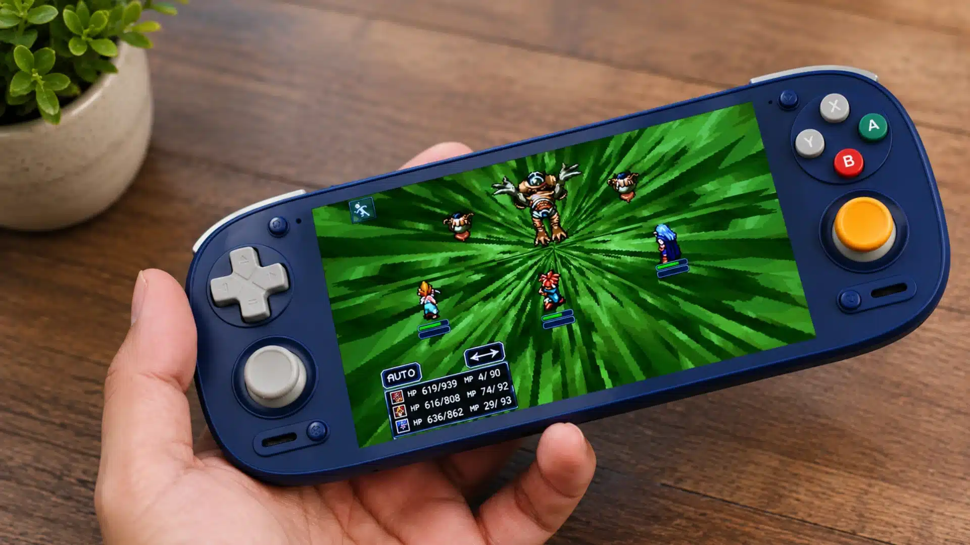 Blue handheld console shows a retro RPG battle while held above a wooden table