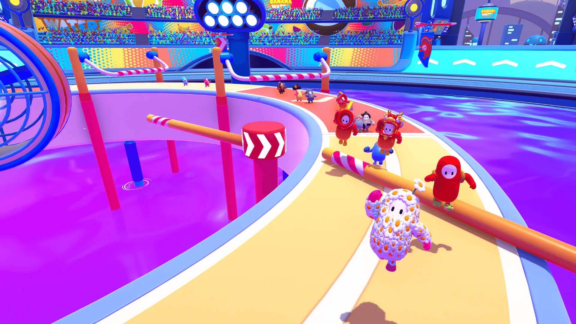 Fall Guys gameplay scene with colorful characters racing past spinning obstacles in arena