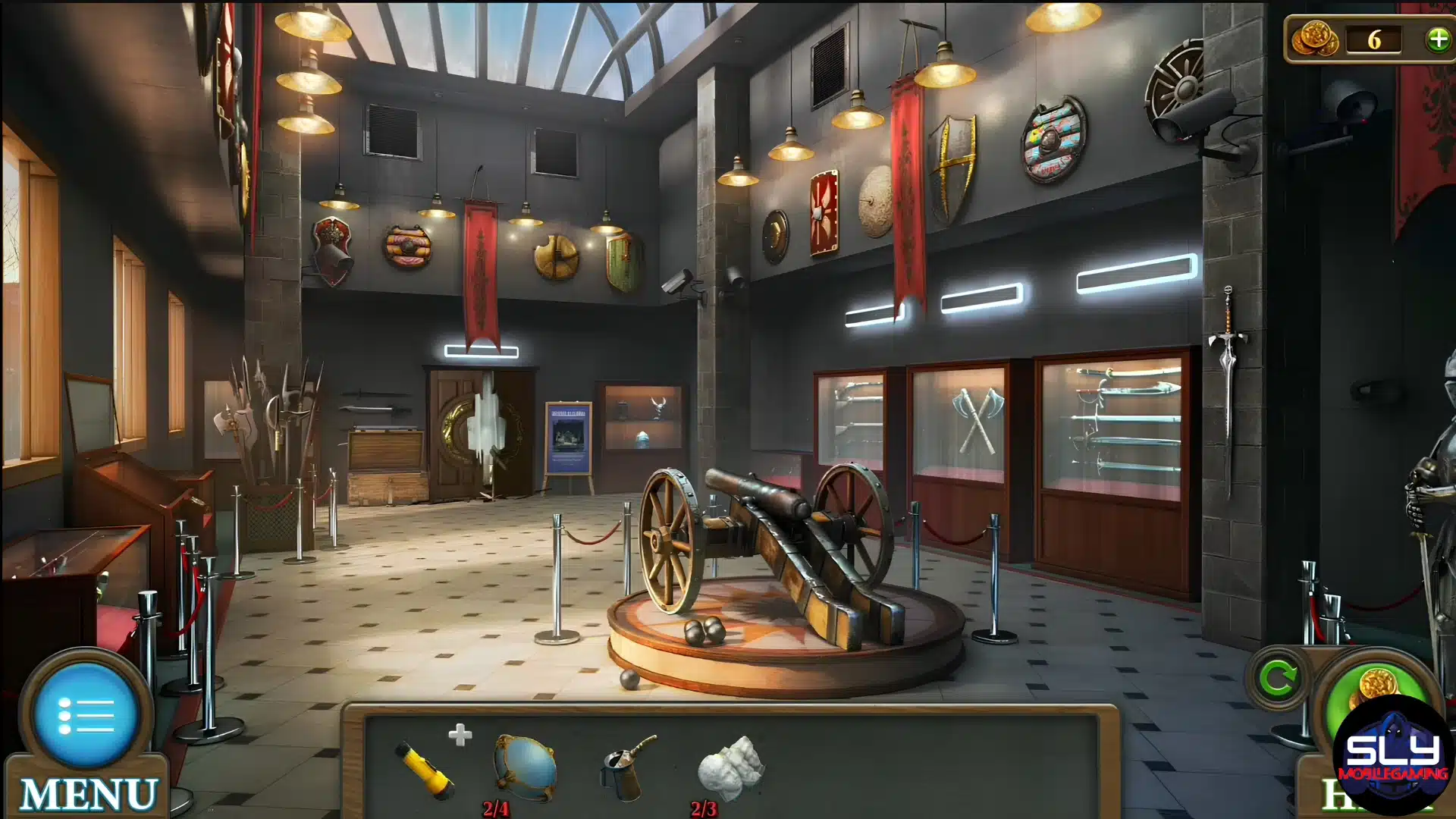 A museum hall displaying medieval weapons, shields, and a historic cannon in the center.