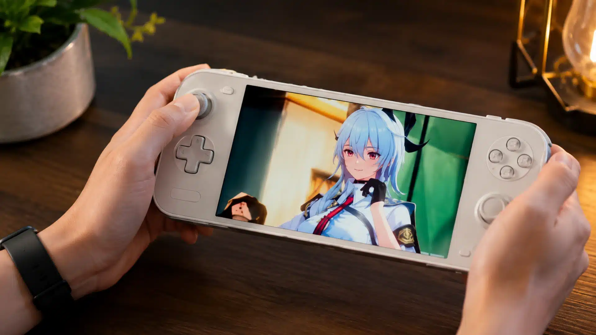 Hands hold a white handheld console showing an anime game on a warmly lit desk indoors